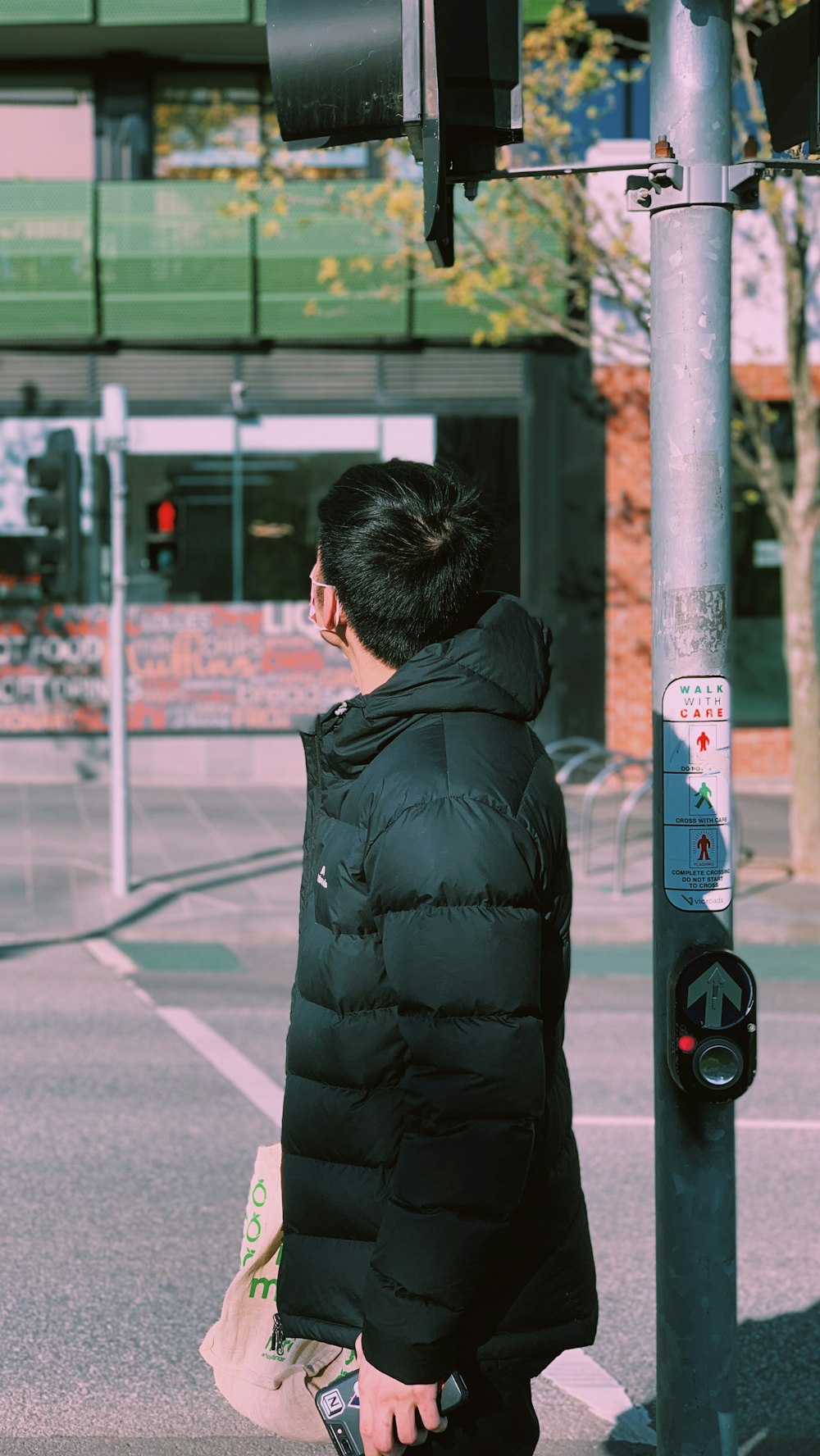 man in black jacket standing near white and black post