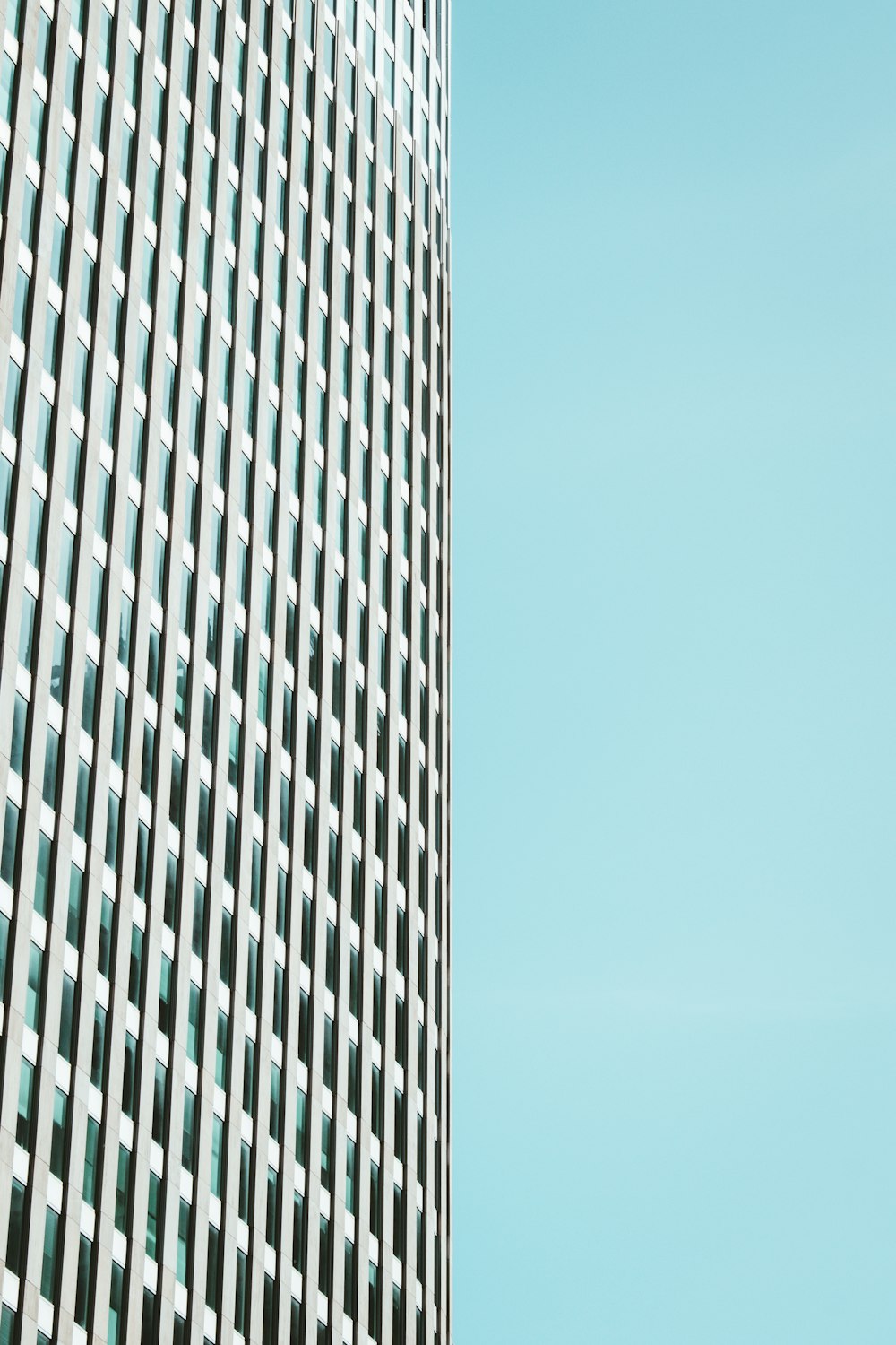 Weißes Betongebäude unter blauem Himmel tagsüber