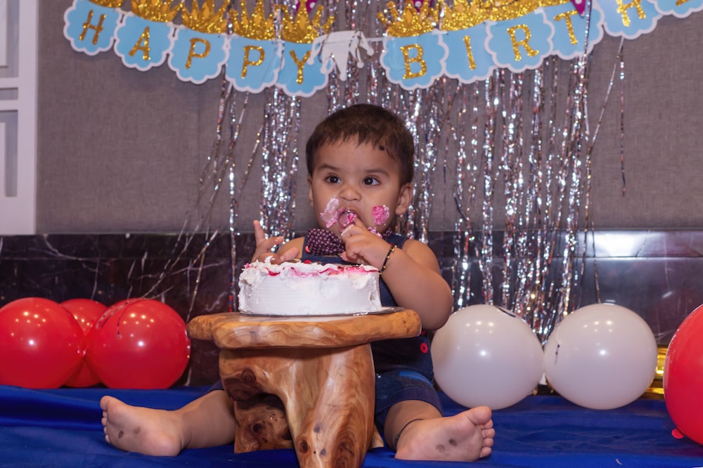 girl in pink tank top sitting on blue inflatable pool with cake on top