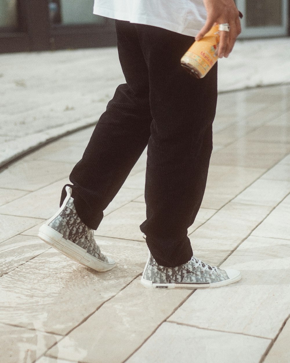 person in black pants and gray and white sneakers