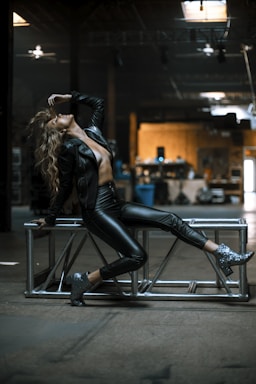 woman in black leather jacket and black pants sitting on bar seat