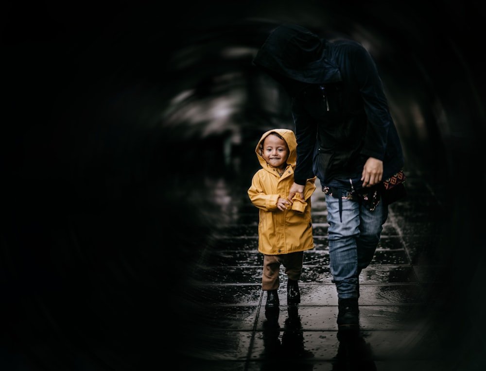 girl in yellow coat and black leather boots standing on water