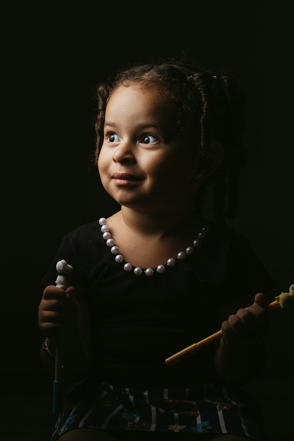 girl in black crew neck shirt holding brown stick