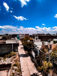 A quiet neighborhood street with empty plots for sale.