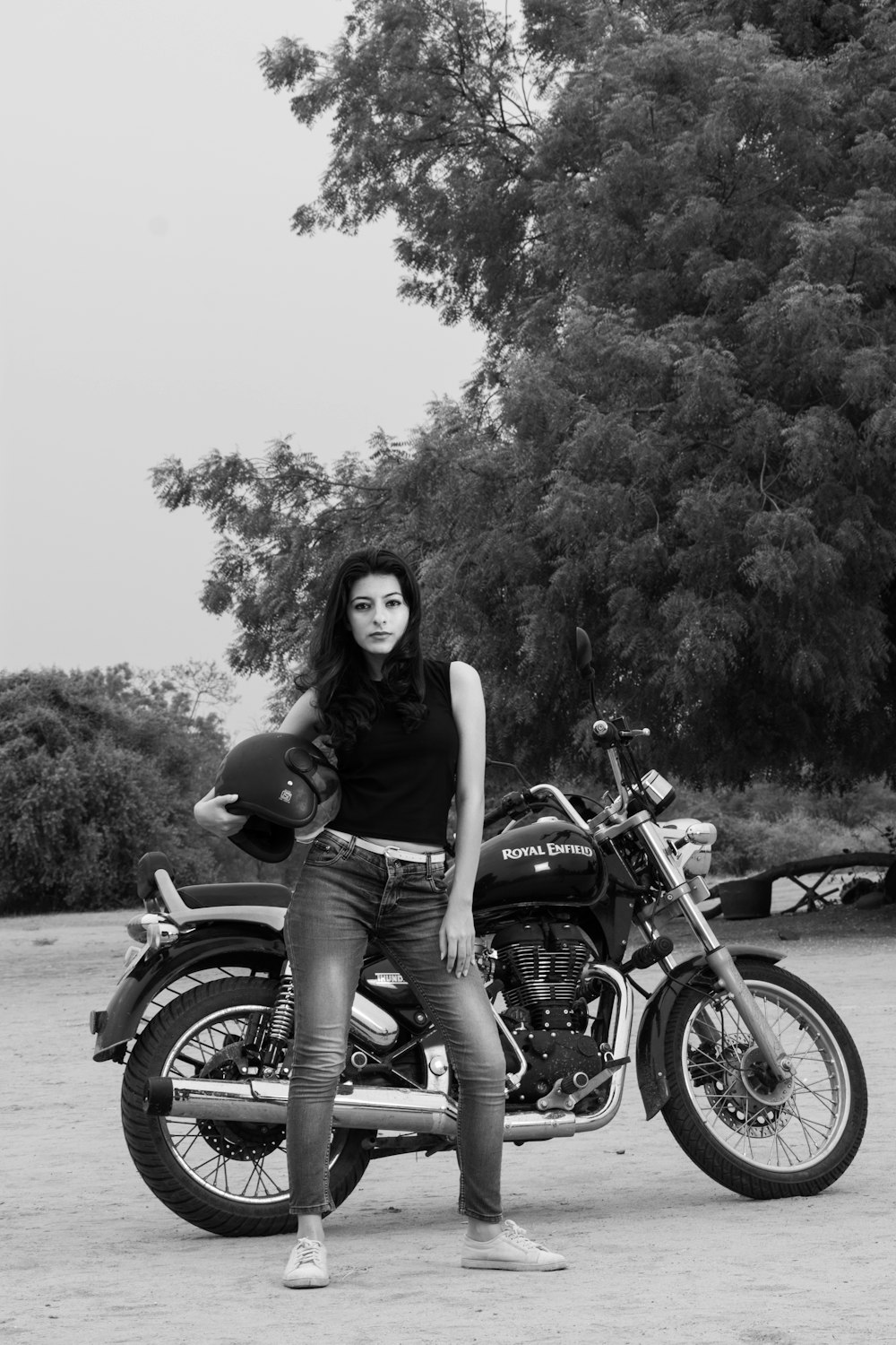 woman in black tank top and blue denim shorts sitting on black motorcycle