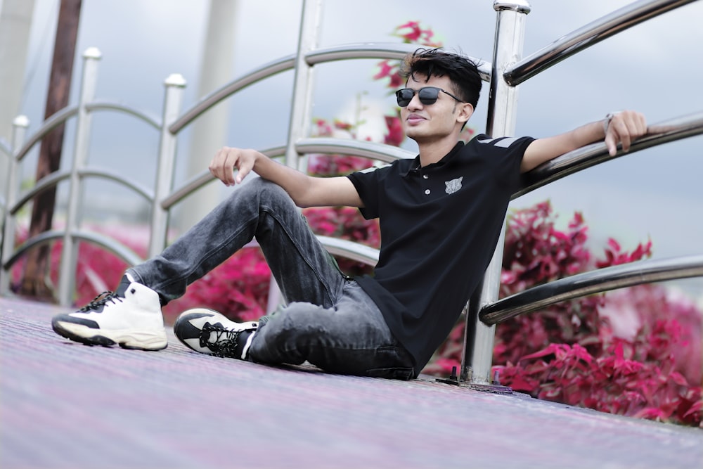 man in black crew neck t-shirt and blue denim jeans wearing white and red sunglasses