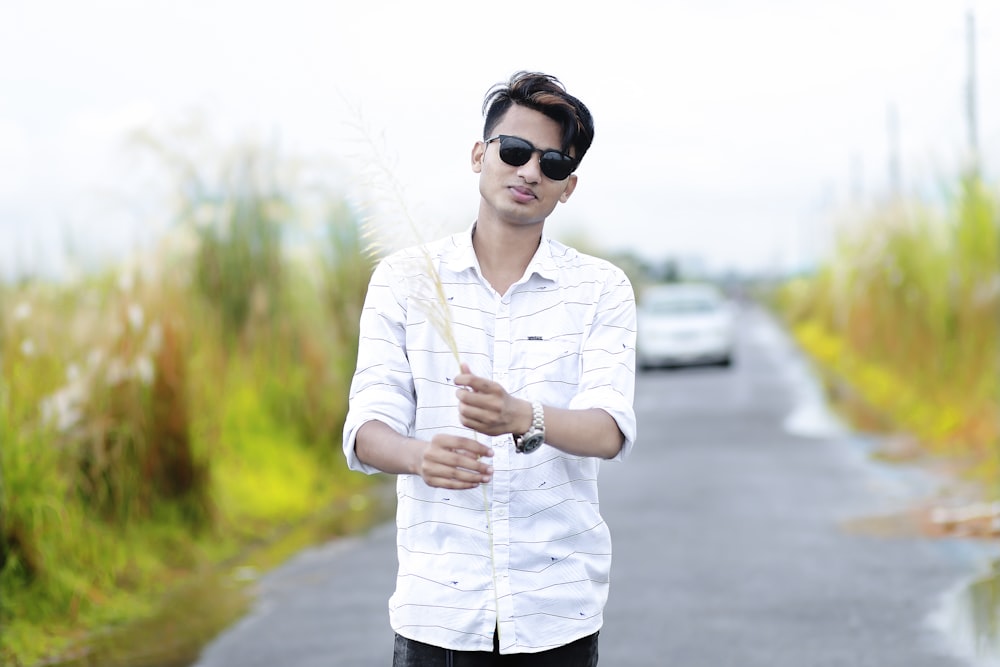 woman in white and black stripe shirt and black sunglasses holding white stick