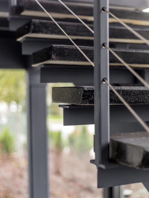 Before and after of a sleek wooden staircase with metal railings in a modern home.