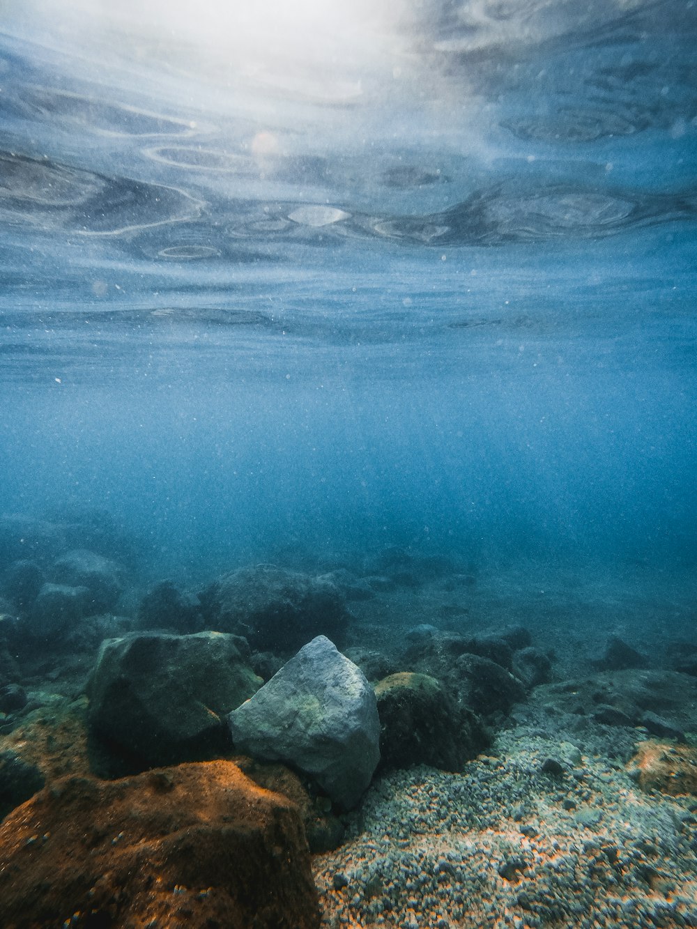 Plan d’eau bleu avec des roches grises