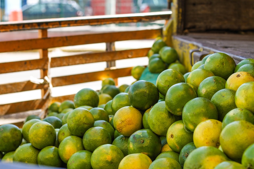 green round fruits on brown wooden crate