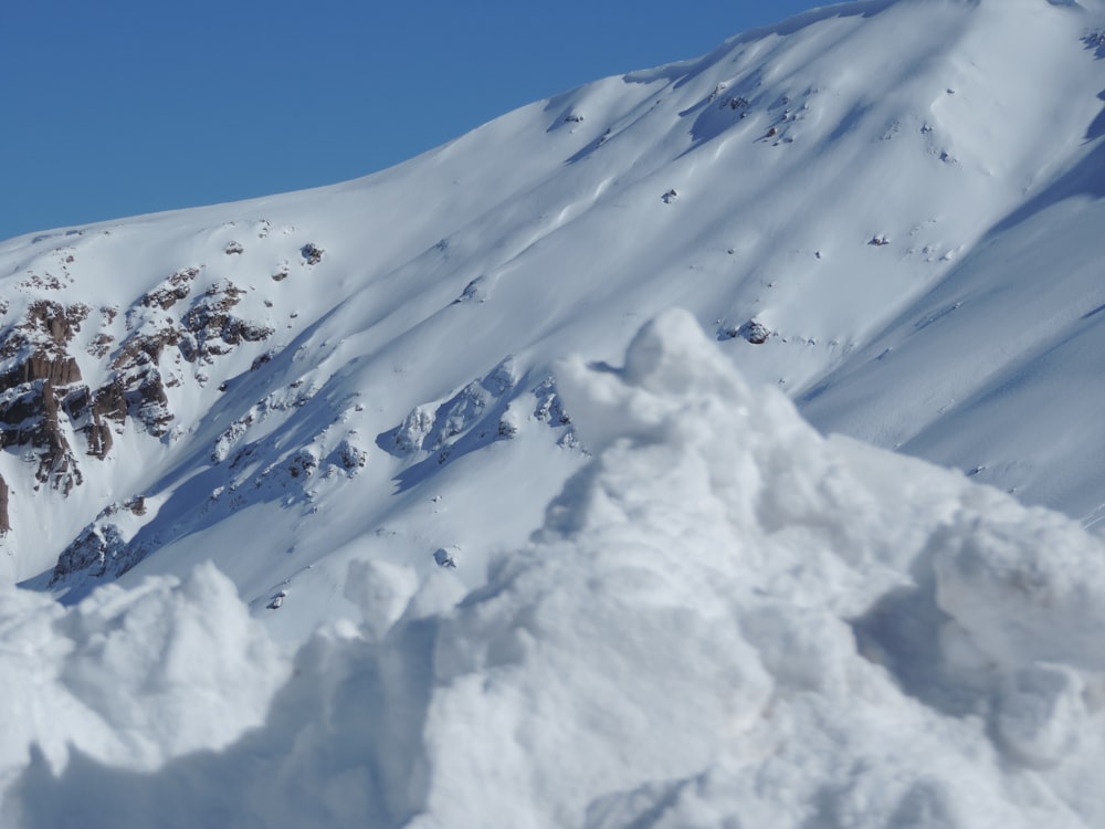 montanha coberta de neve sob o céu azul durante o dia