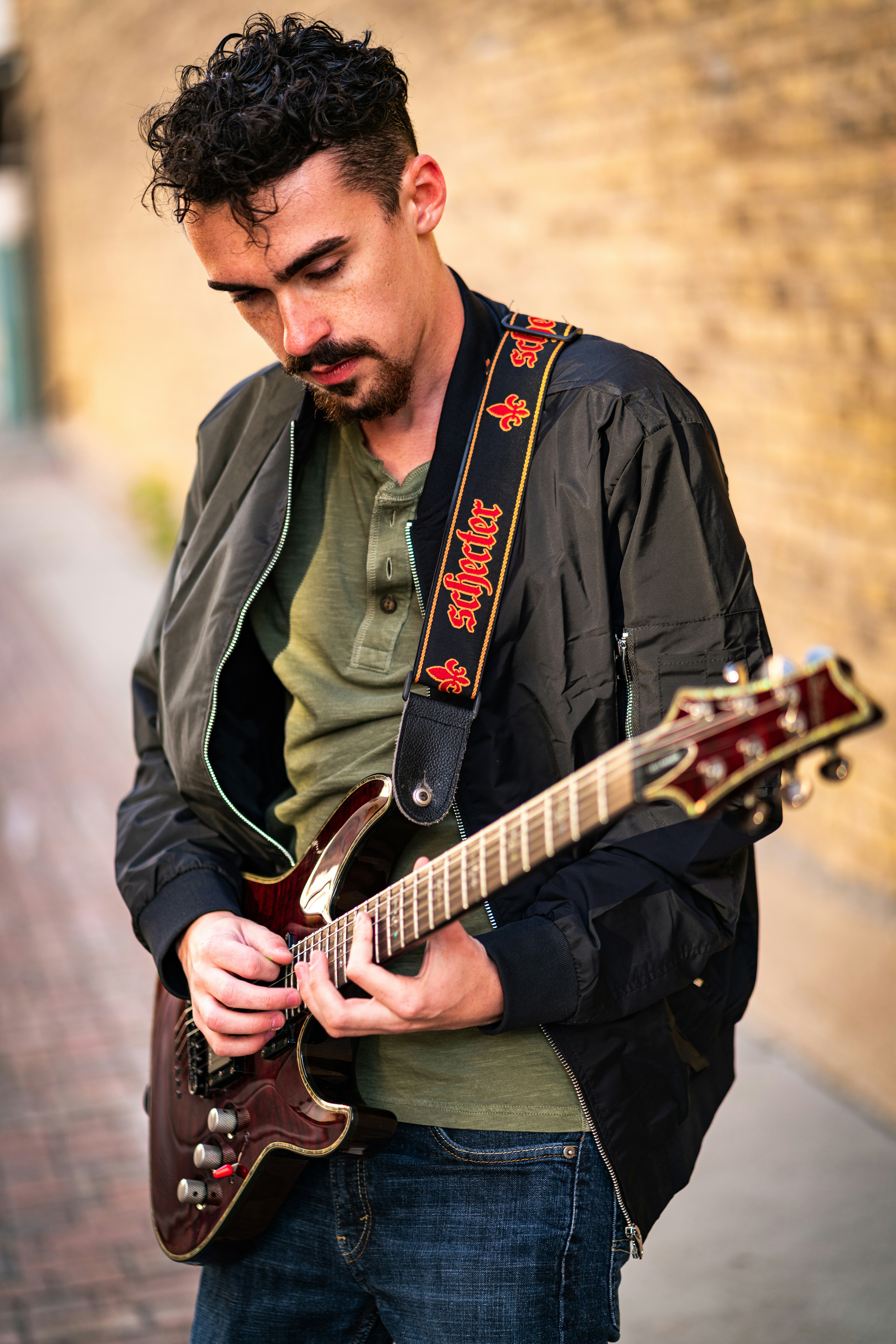 man in gray jacket playing guitar