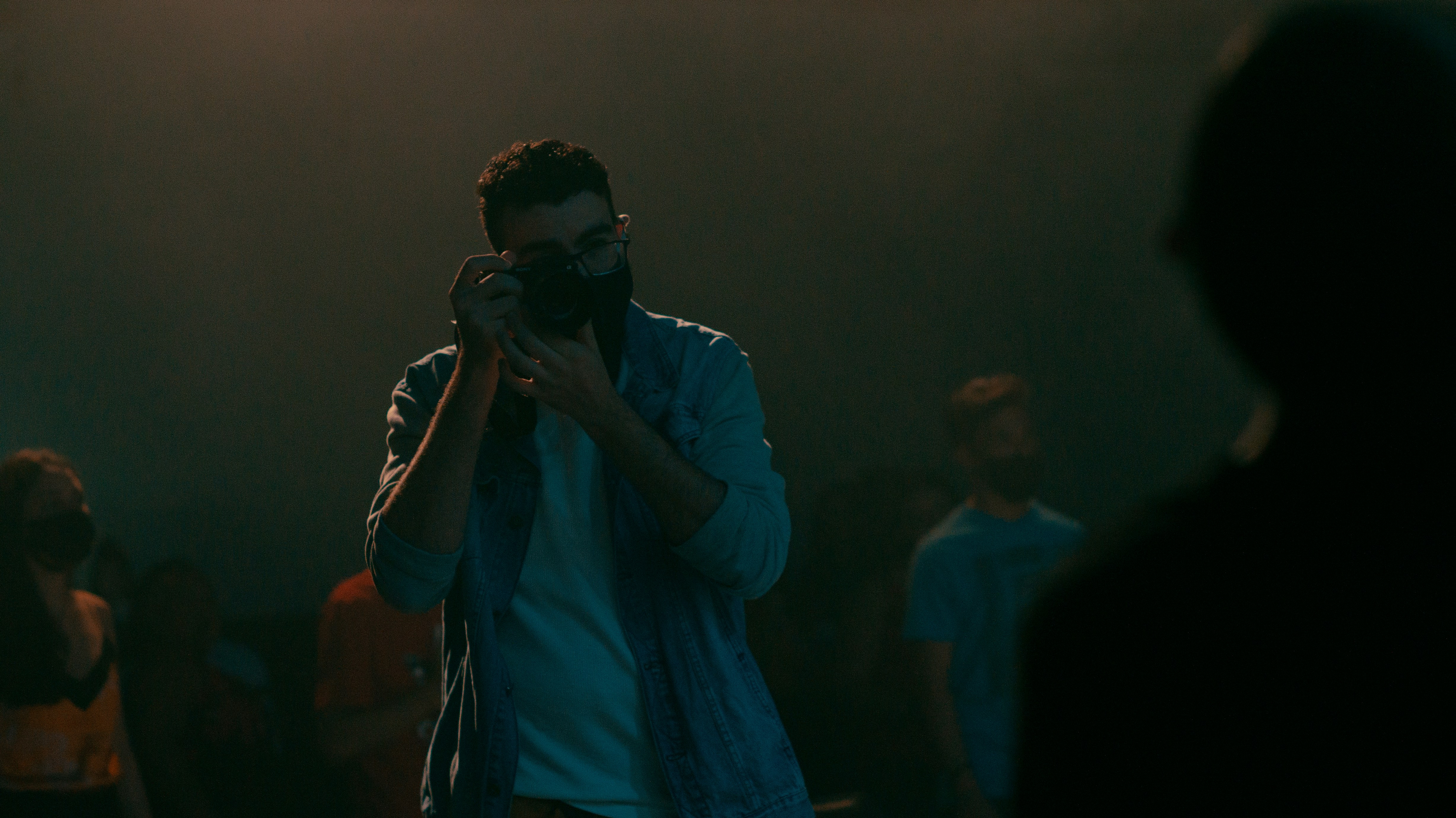 man in blue dress shirt holding black dslr camera