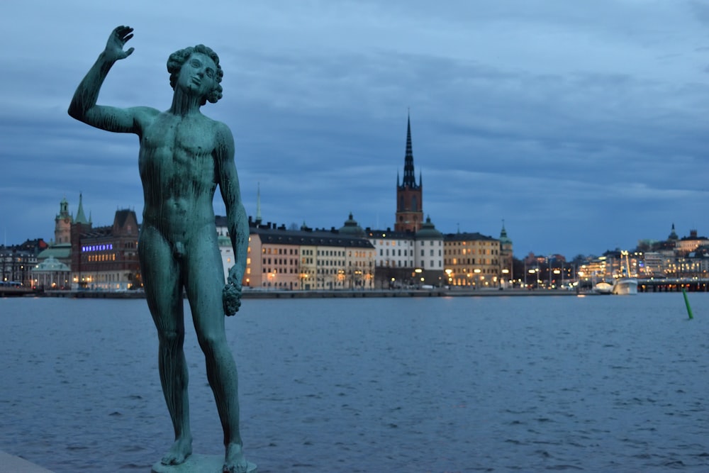 estátua do homem perto do corpo de água durante o dia