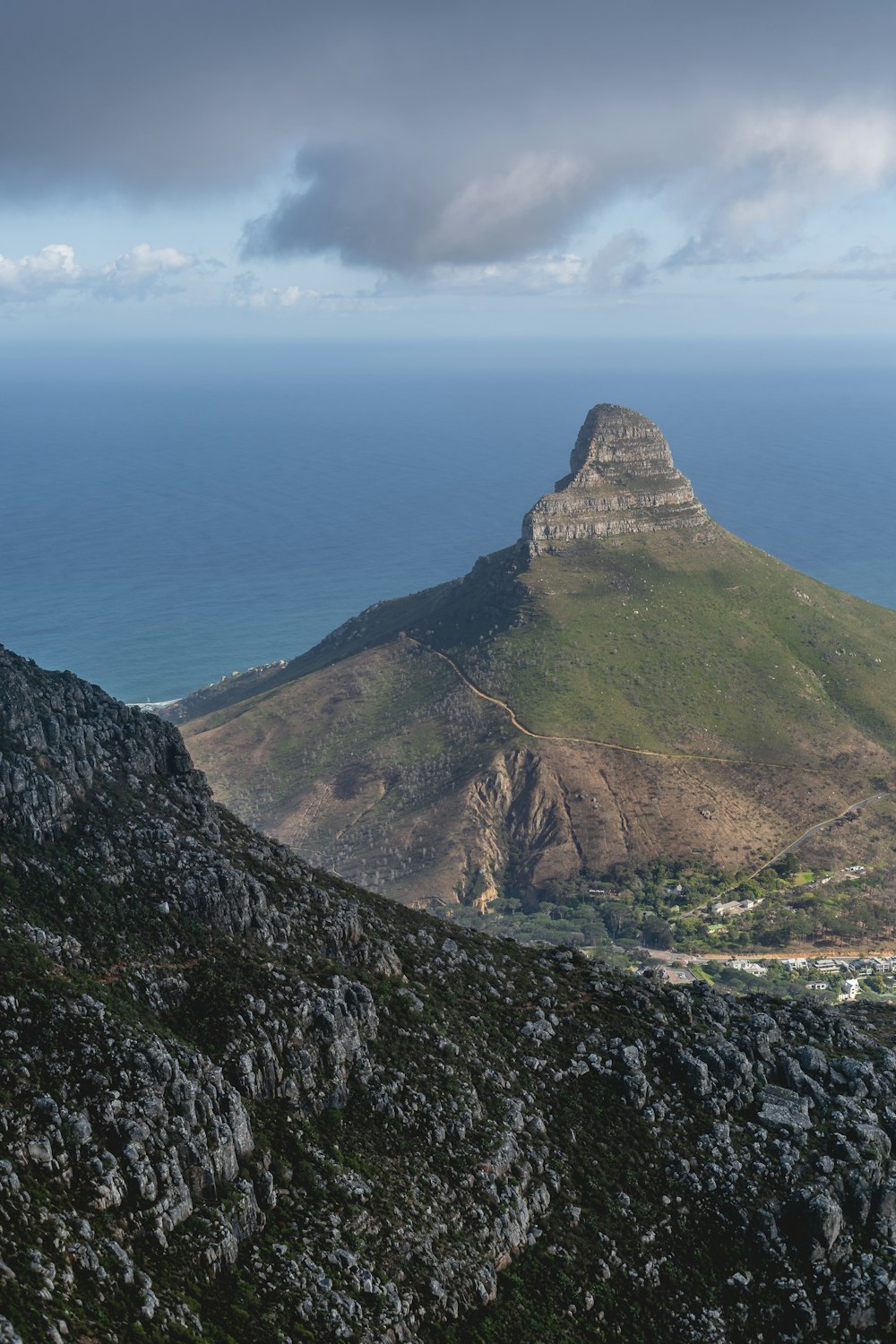 brown and green mountain beside body of water during daytime