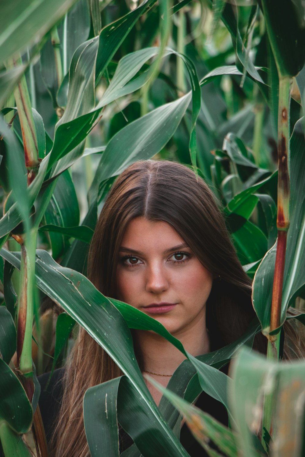 woman in green scarf surrounded by green leaves