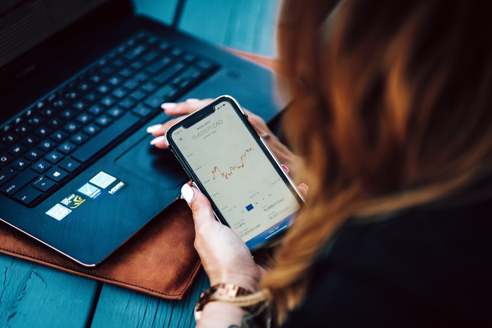 woman holding black android smartphone