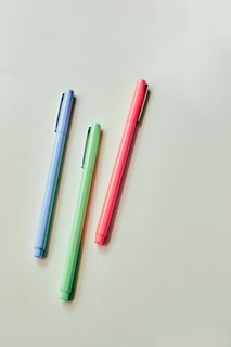 pink and blue pen on white table