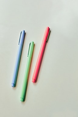 pink and blue pen on white table