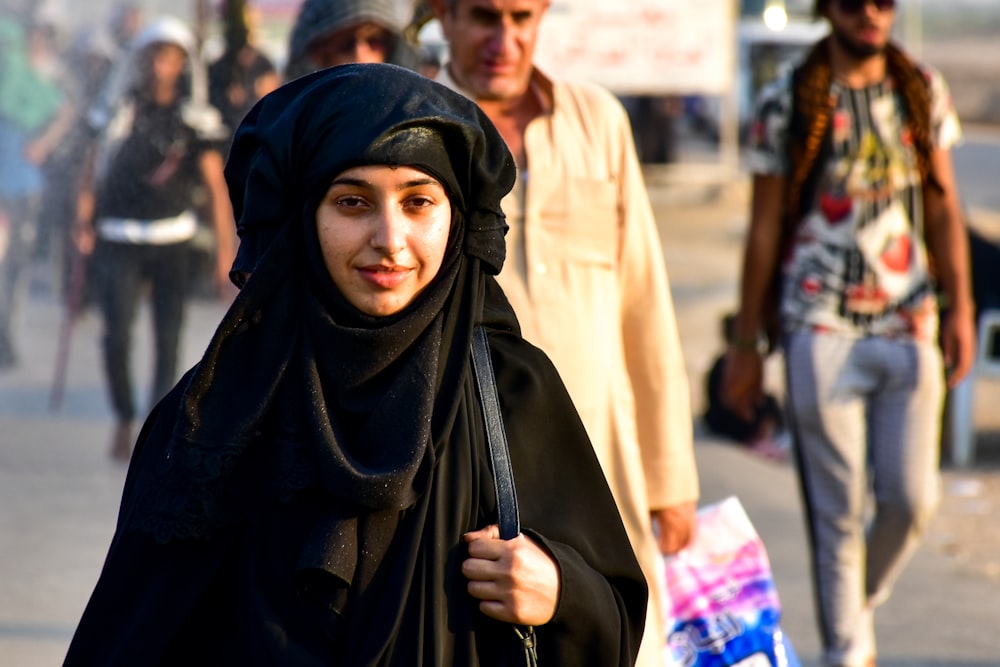 woman in black hijab standing near people during daytime