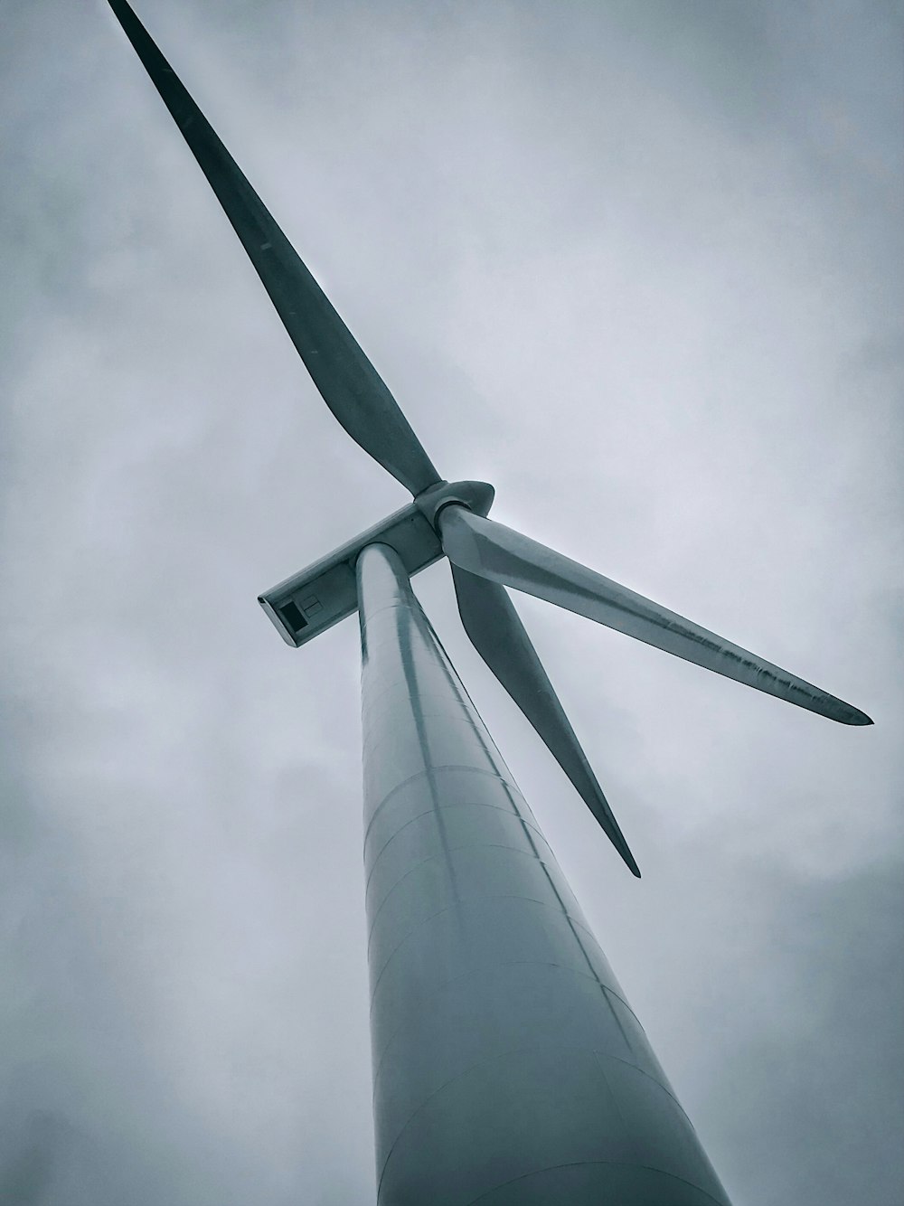 white wind turbine under white sky