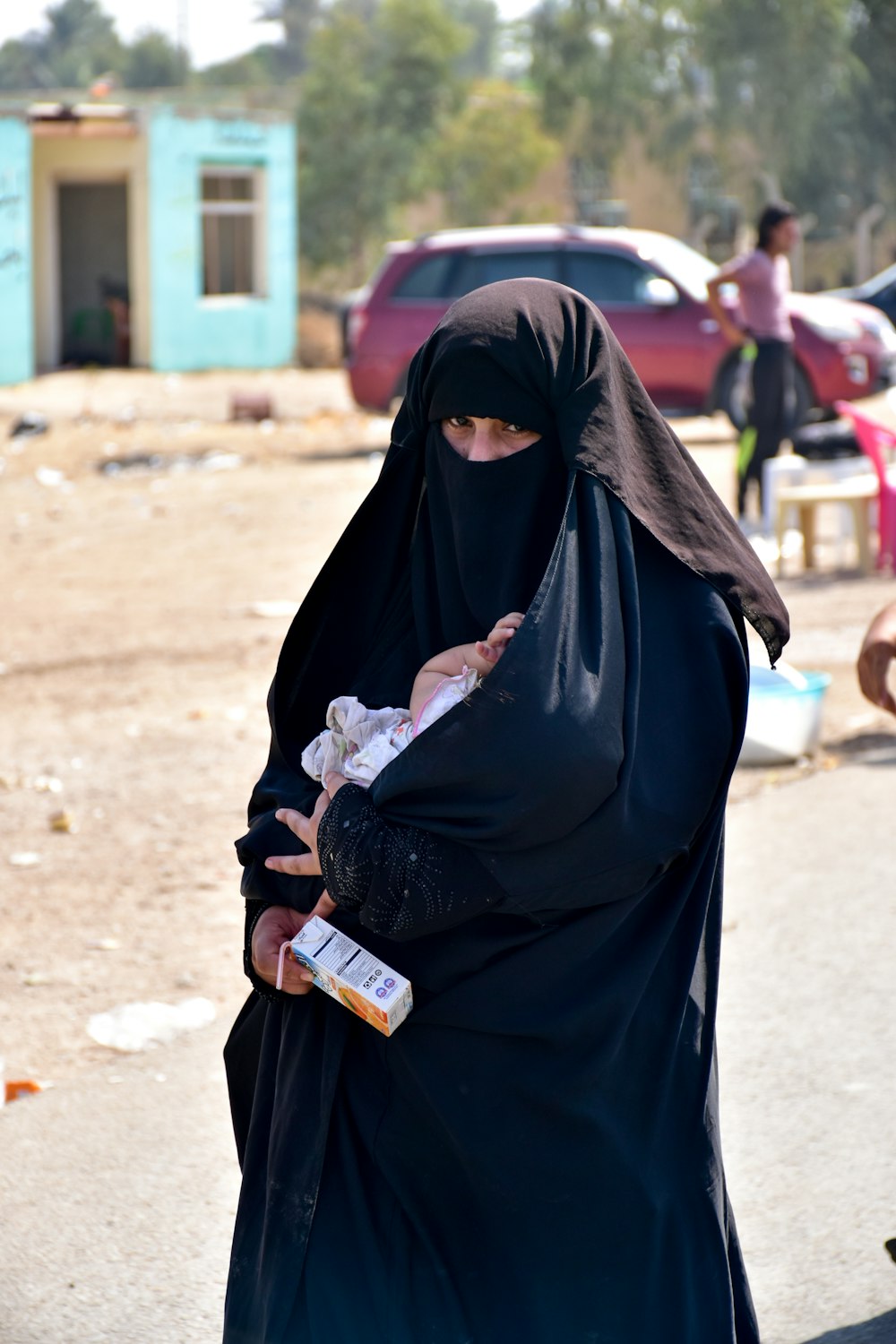 woman in black hijab holding bottle