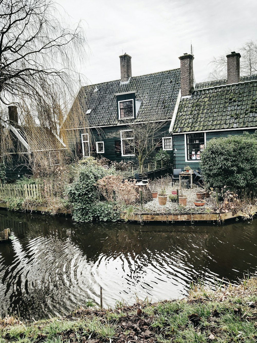 brown and white concrete house beside river during daytime