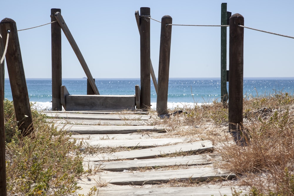 brown wooden ladder on white sand near body of water during daytime