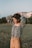 woman in black and white floral long sleeve shirt and brown denim shorts standing on field