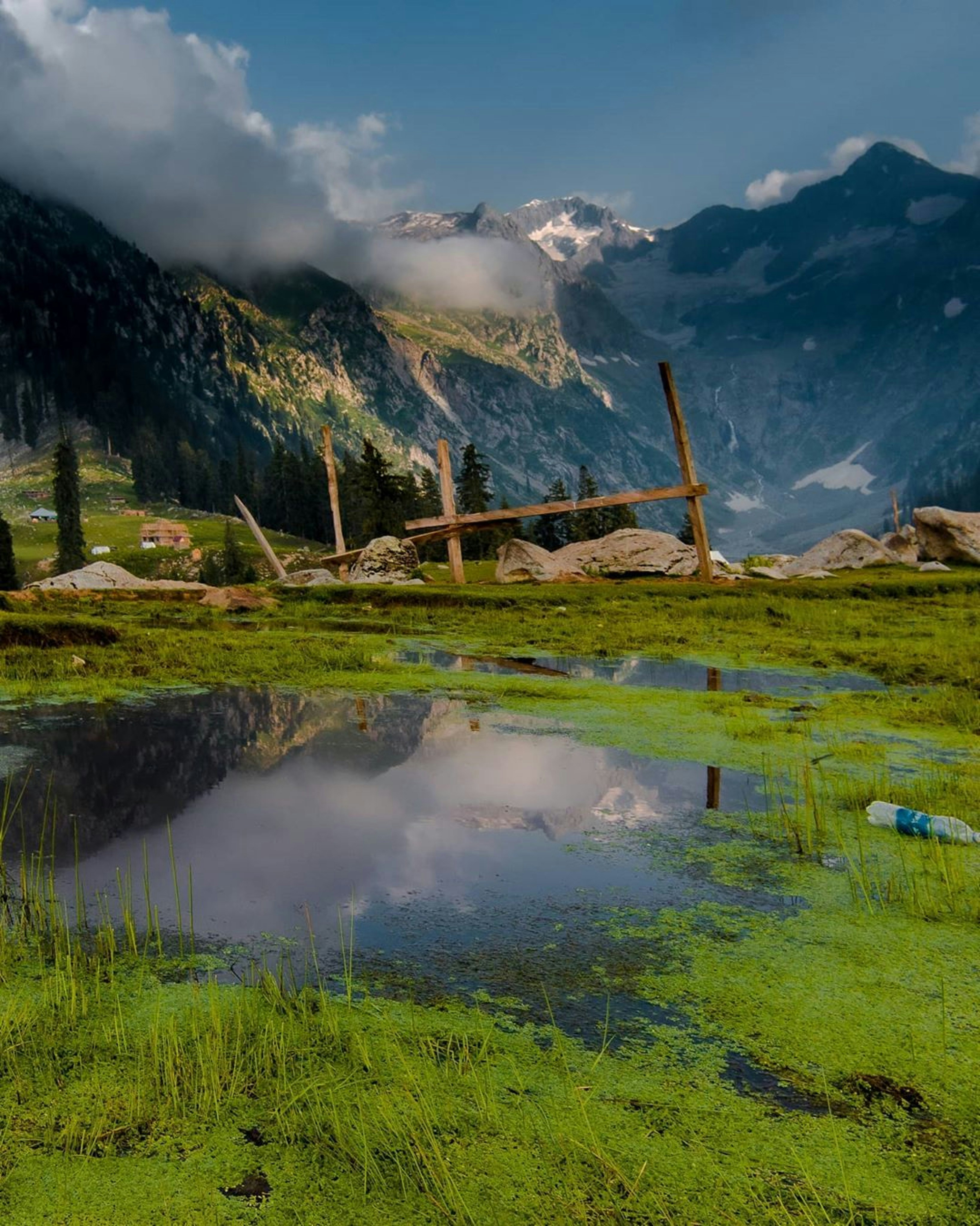 brown wooden fence on green grass field near mountain during daytime