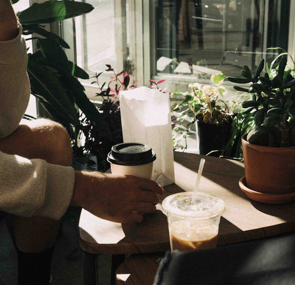 person holding black and white ceramic mug