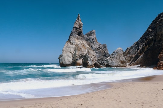 brown rock formation on sea shore during daytime in Sintra-Cascais Natural Park Portugal