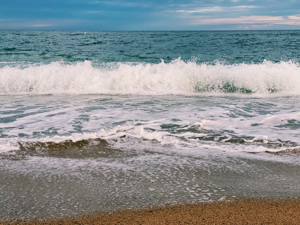 ocean waves crashing on shore during daytime