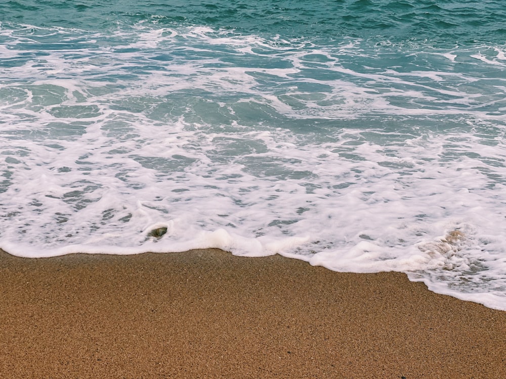 sea waves crashing on shore during daytime