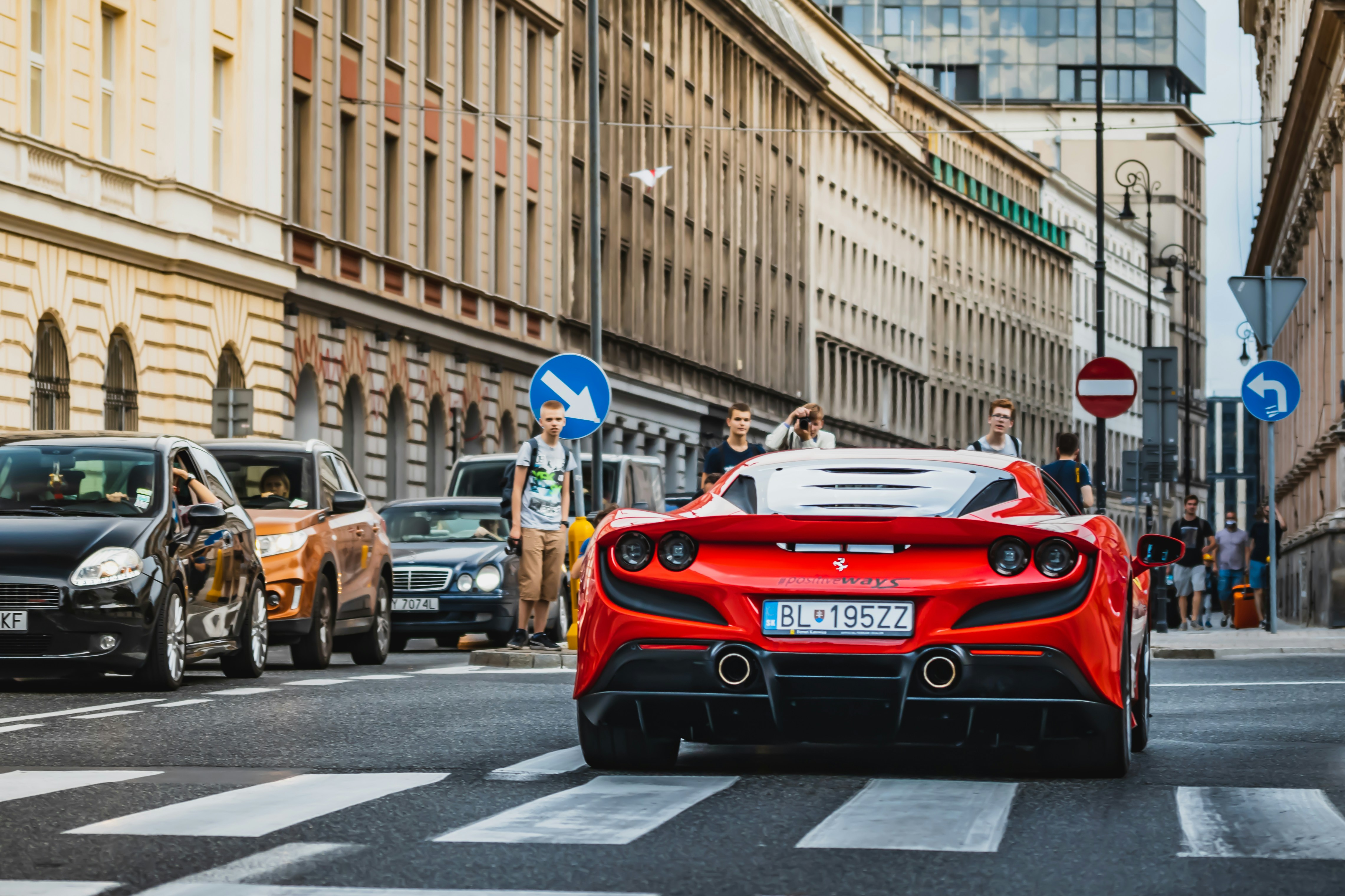 a red sports car driving down a city street