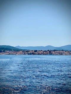 body of water near mountain during daytime