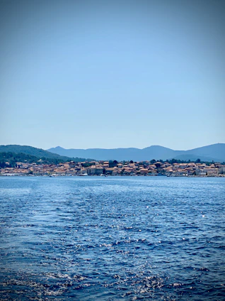 body of water near mountain during daytime