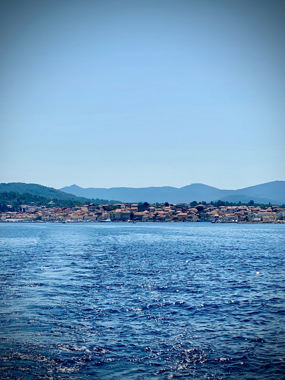 body of water near mountain during daytime