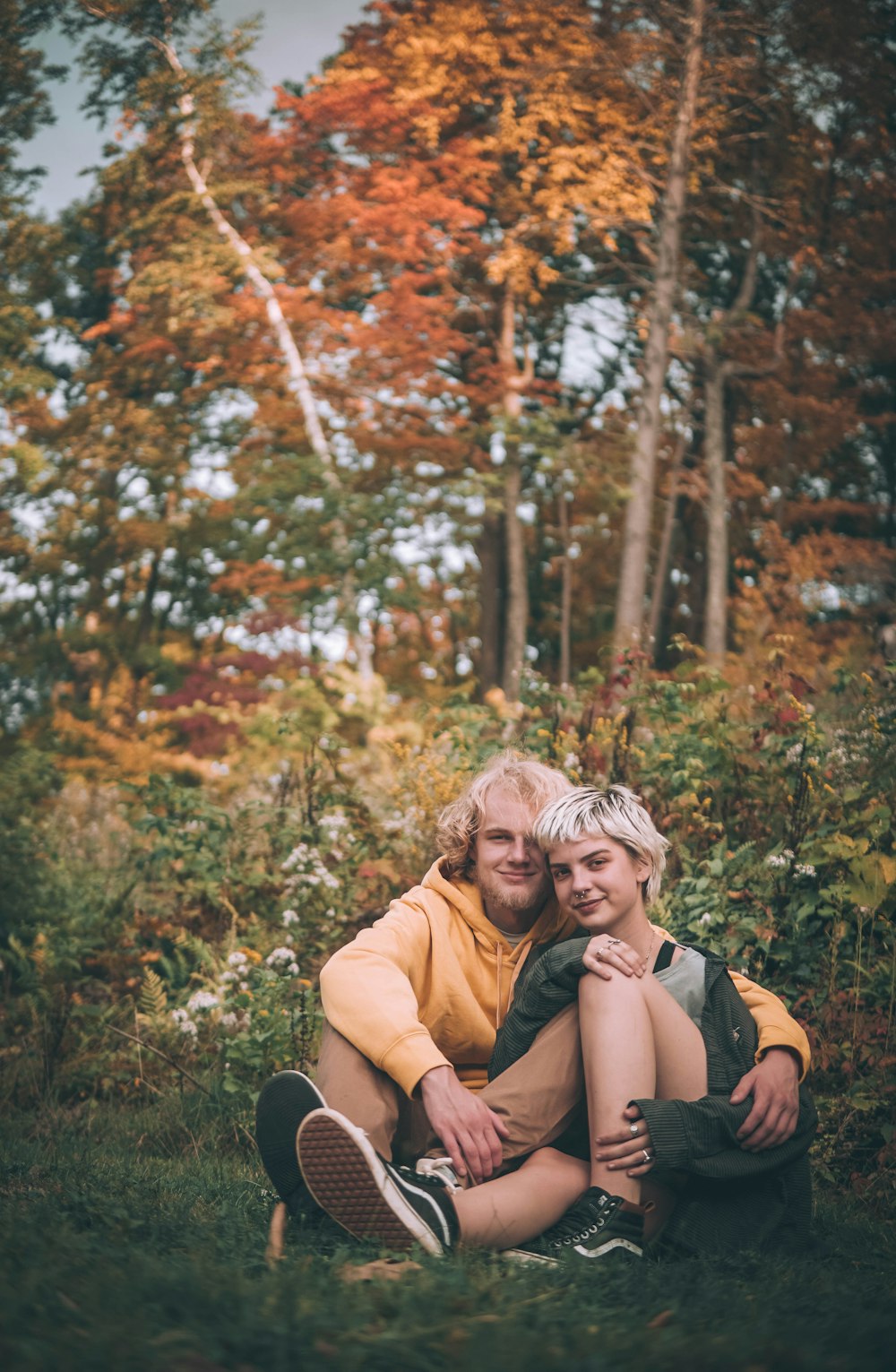 man in brown shirt hugging woman in black jacket