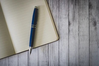 blue click pen on brown wooden table