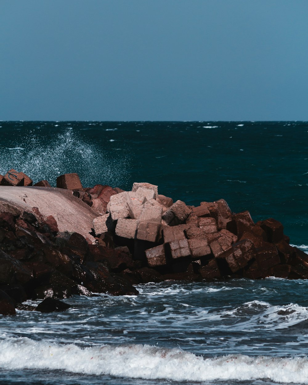 brown rock formation near body of water during daytime