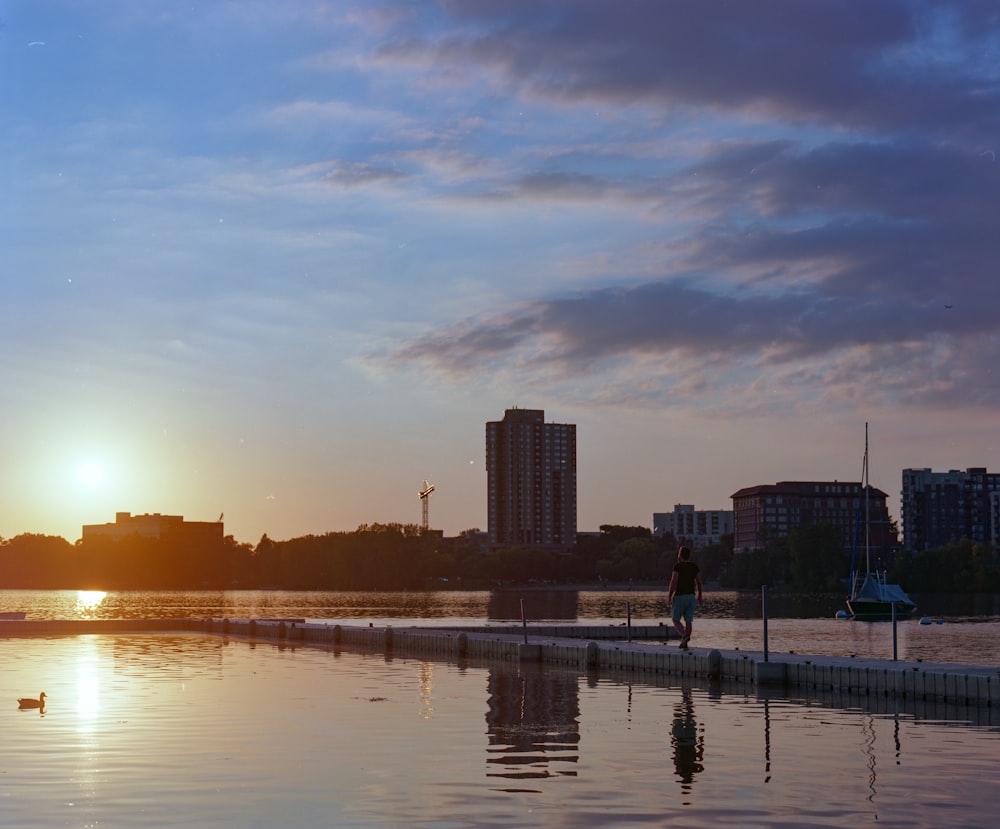 city skyline across body of water during sunset