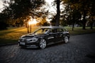 black bmw m 3 parked on sidewalk during sunset