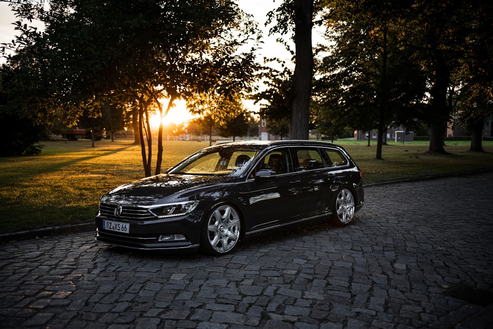 Schwarzer BMW M 3 parkt bei Sonnenuntergang auf Gehweg