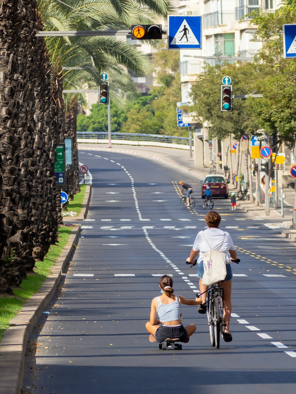 man in white t-shirt riding bicycle on road during daytime