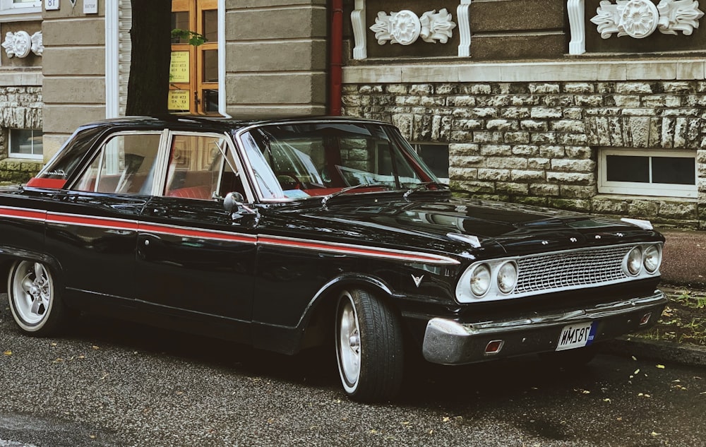 black car parked beside brown brick wall