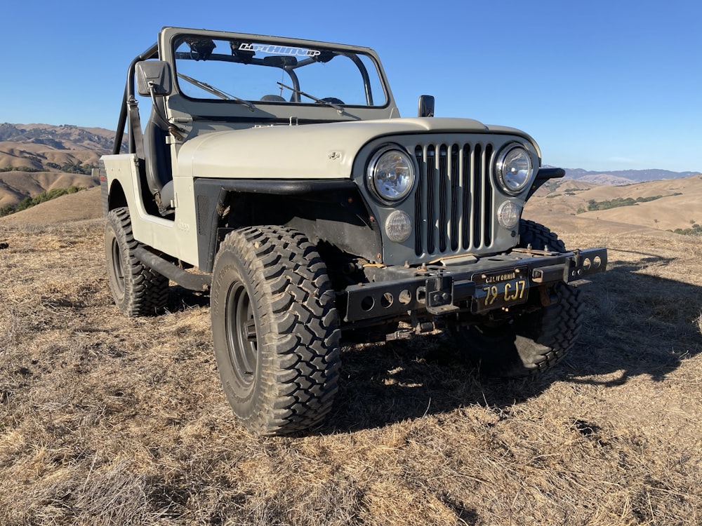 white and black jeep wrangler on brown sand during daytime