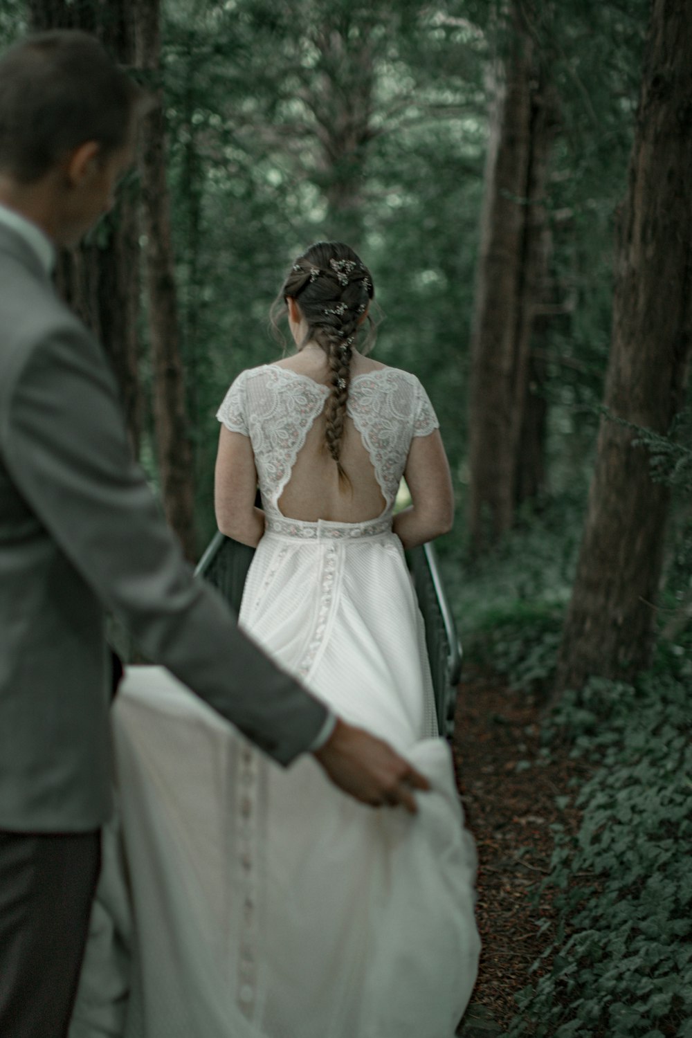 man and woman in wedding dress standing on forest during daytime