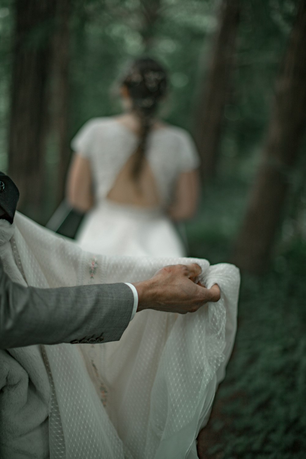 man in gray suit jacket holding woman in white dress