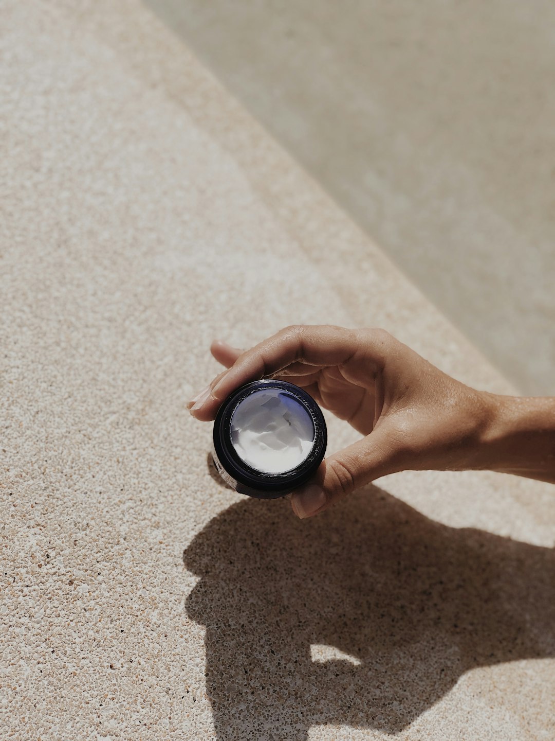 person holding black round container